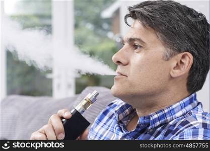 Mature Man Using Vapourizer As Smoking Alternative