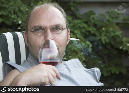 Mature man with a cigarette sticking out of his ear, depicting the fact that he refuses to listen to all the good advice about quitting smoking