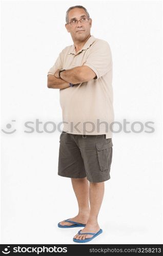 Mature man with his arms crossed looking away