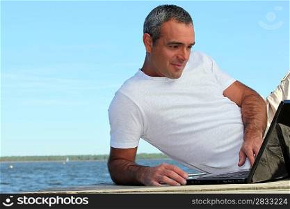 mature man with laptop outside