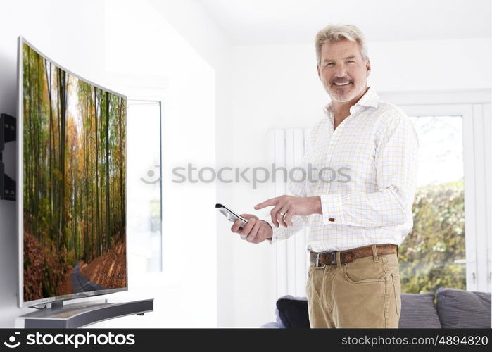 Mature Man With New Curved Screen Television At Home