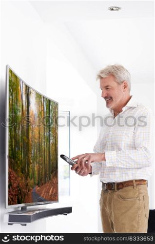 Mature Man With New Curved Screen Television At Home