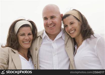 Mature man with two mature women smiling together