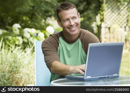 Mature man working on a laptop and smiling