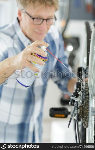 mature mechanic fixes a bike wheel