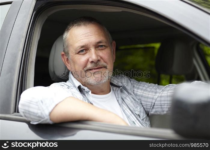 Mature Motorist Looking Out Of Car Window