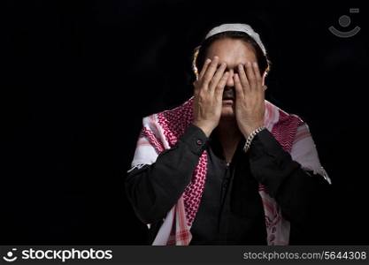 Mature Muslim man praying over black background