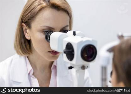 Mature optometrist examining patient at hospital