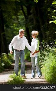 Mature or senior couple deeply in love chasing each other in late spring or early summer