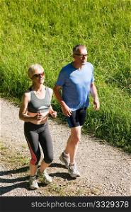 Mature or senior couple doing sport outdoors, jogging