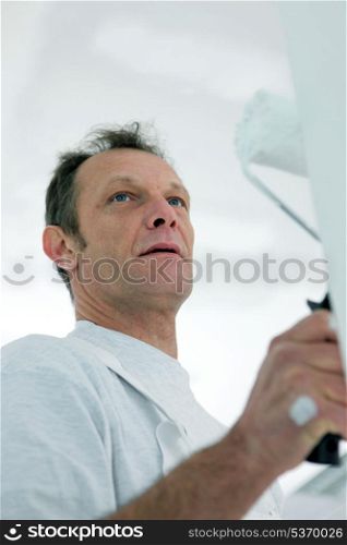 mature painter with roller