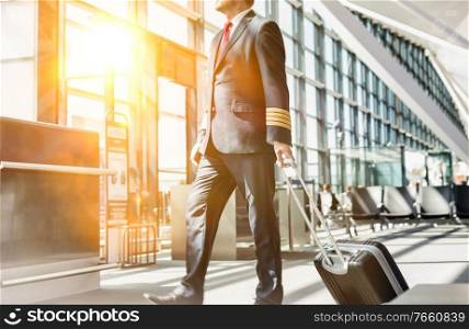 Mature pilot walking to enter the plane in boarding gate at airport