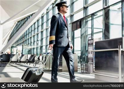 Mature pilot walking to enter the plane in boarding gate at airport