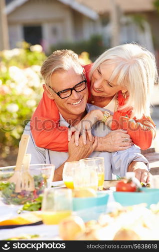 Mature Romantic Couple Enjoying Outdoor Meal In Garden