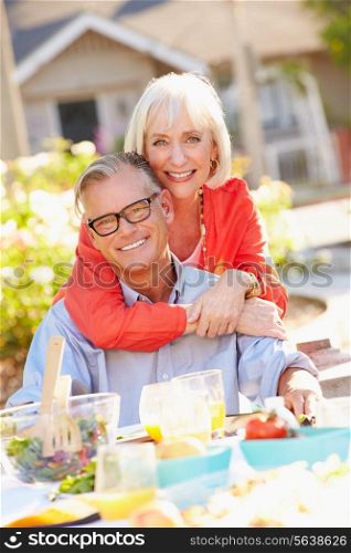 Mature Romantic Couple Enjoying Outdoor Meal In Garden