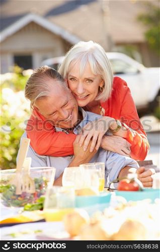 Mature Romantic Couple Enjoying Outdoor Meal In Garden
