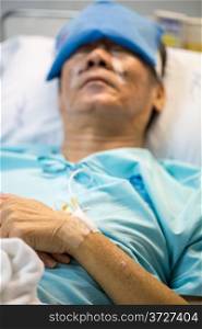 mature senior man Patient sleeping in hospital bed (Selective focus at hand)