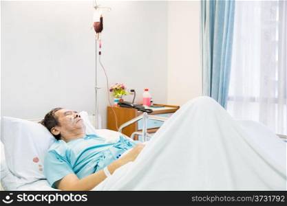 mature senior man Patient sleeping in hospital bed with blood infusion