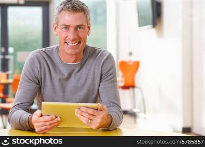 Mature Student Studying In Classroom With Digital Tablet