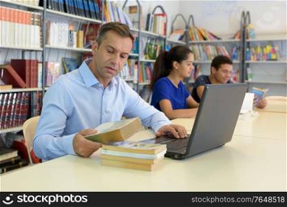 mature student using laptop at college library