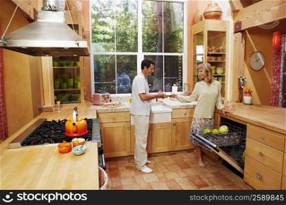 Mature woman and a mature man standing in the kitchen