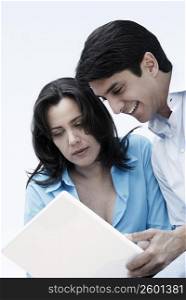 Mature woman and a mid adult man looking at a laptop