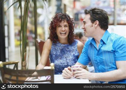 Mature woman and a mid adult man sitting in a cafe