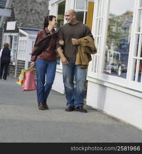 Mature woman and a mid adult man walking on the road and smiling