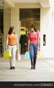 Mature woman and a mid adult woman carrying shopping bags