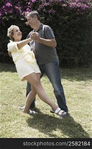Mature woman and a senior man dancing in a garden