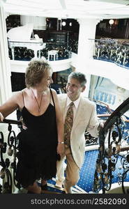 Mature woman and a senior man moving up on a staircase of a ship