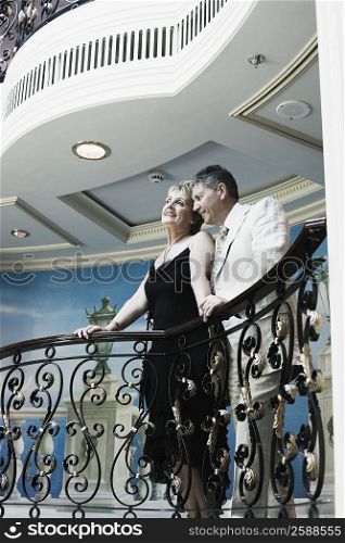 Mature woman and a senior man standing at the balcony of a ship