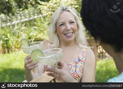 Mature woman and a woman holding glasses of martini