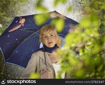 Mature woman and an umbrella, rainy summer day.