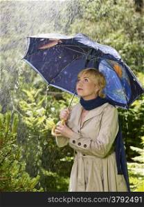 Mature woman and an umbrella, rainy summer day.