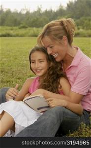 Mature woman and her daughter sitting in the park