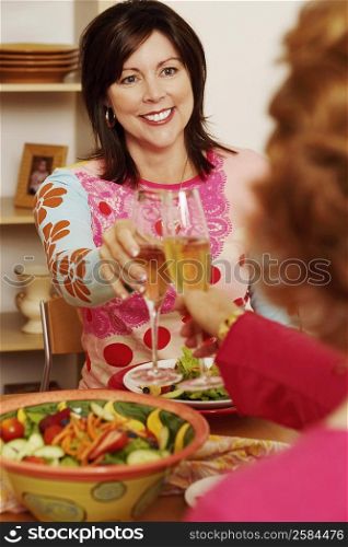 Mature woman and her friend toasting with champagne flutes