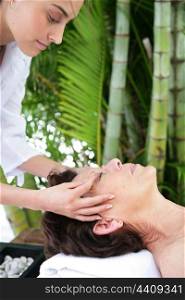 mature woman being massaged in exotic setting