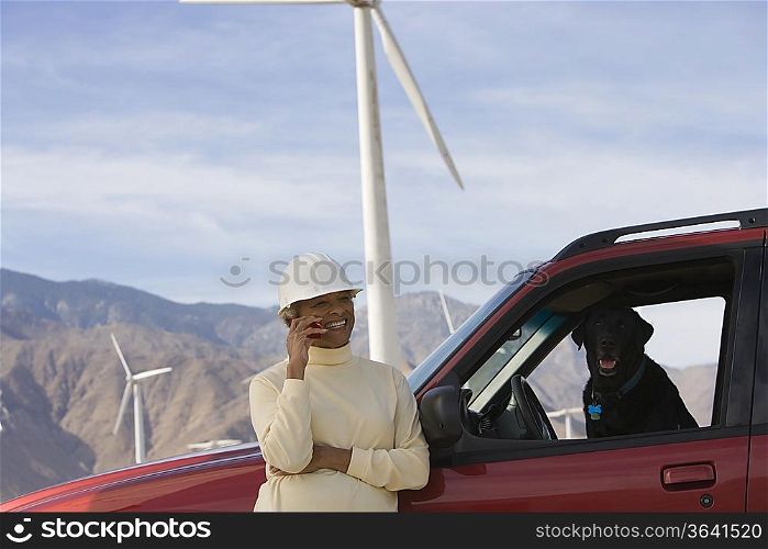 Mature woman by truck at wind farm