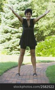 Mature woman cheering with her arm outstretched in a park