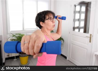mature woman do exercises with dumbbells, indoors