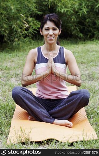 Mature woman doing yoga on the lawn