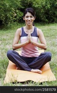 Mature woman doing yoga on the lawn