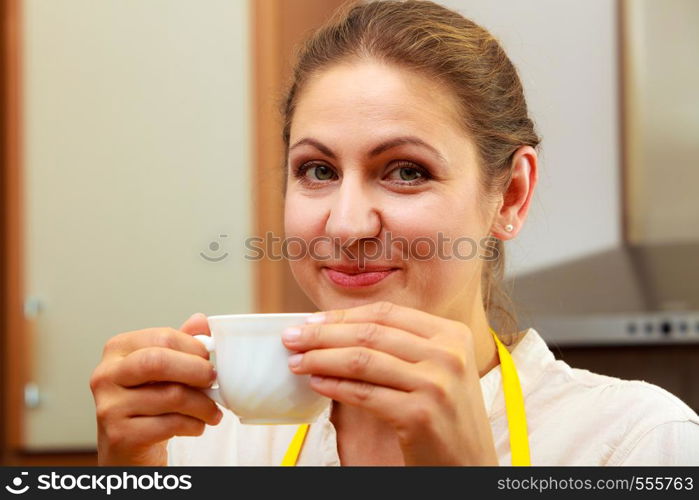 Mature woman drinking cup of coffee in kitchen. Housewife female with hot energizing beverage. Caffeine energy.. Mature woman drinking cup of coffee in kitchen.