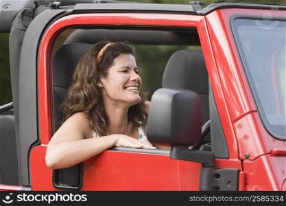 Mature woman driving a jeep and smiling
