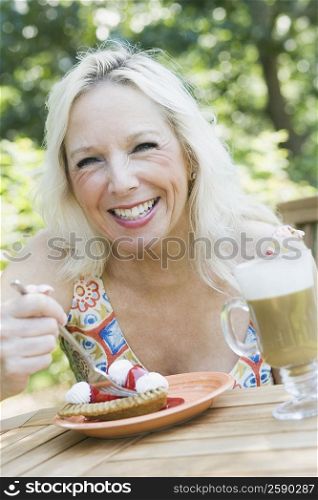 Mature woman eating a fruit tart