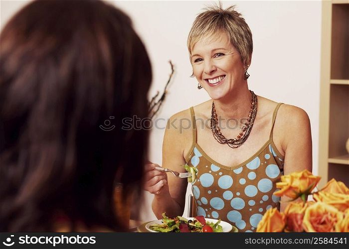 Mature woman eating salad with her friend