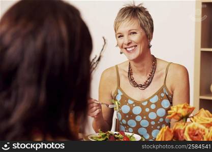 Mature woman eating salad with her friend