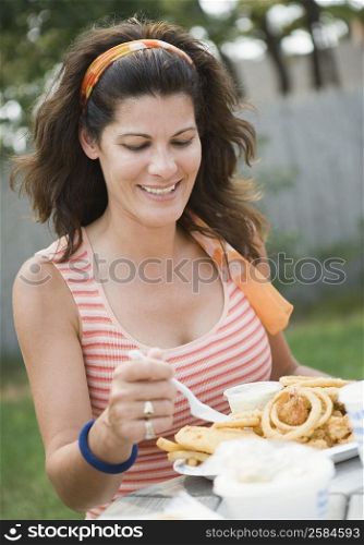 Mature woman eating snacks and smiling