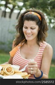 Mature woman eating snacks and smiling